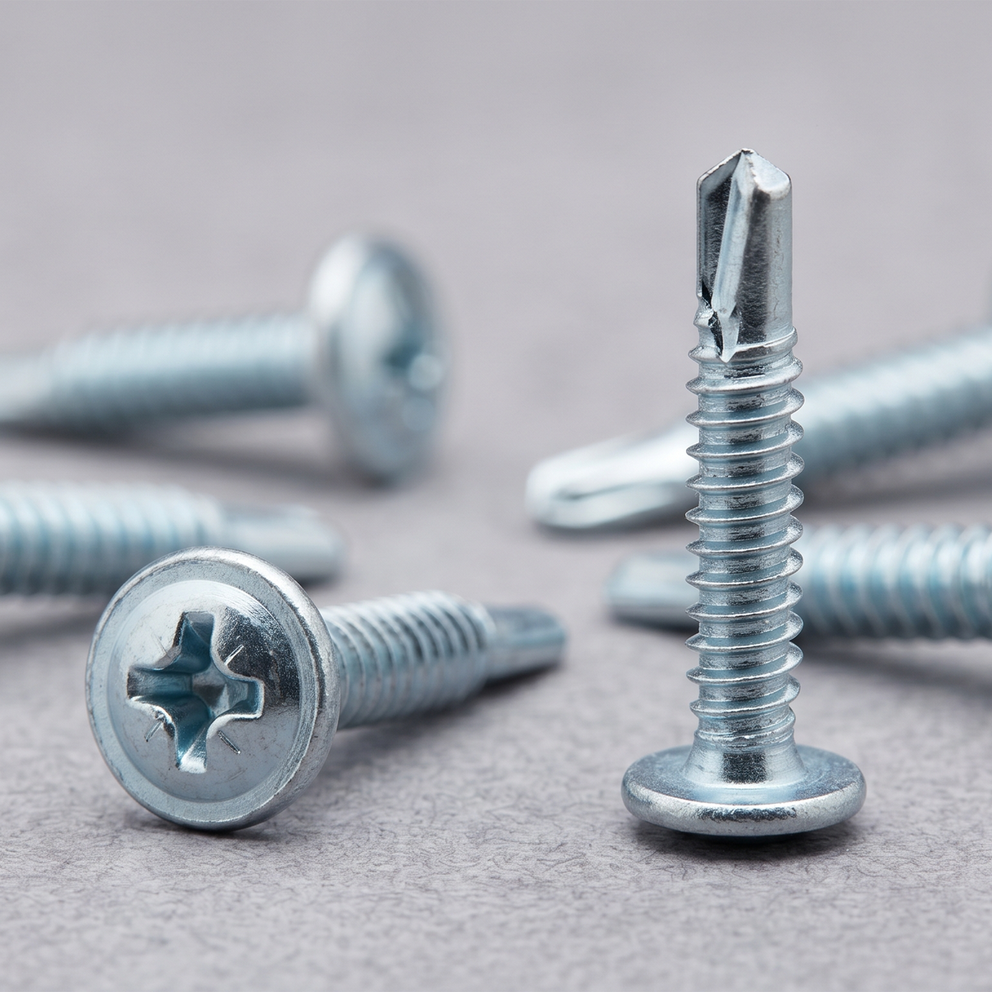 Close-up of a bright zinc-plated self-drilling baypole screw with a low-profile wafer head, designed for flush UPVC window installations.